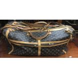 A large Louis Vuitton designer travel bag with lined interior and extra shoulder straps.Approx