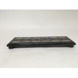 An ebony and mother of pearl cribbage board with one end piece missing. Includes a packet of