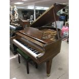 A Kimball baby grand piano with piano stool.