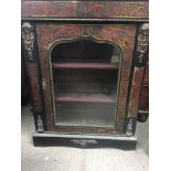 A boule pair cabinet with brass inlay and gilt metal mounts the single door enclosing selfs on a