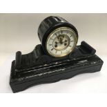 An 8 day slate and marble mantle clock with scrollwork decoration, the white clock face having Roman