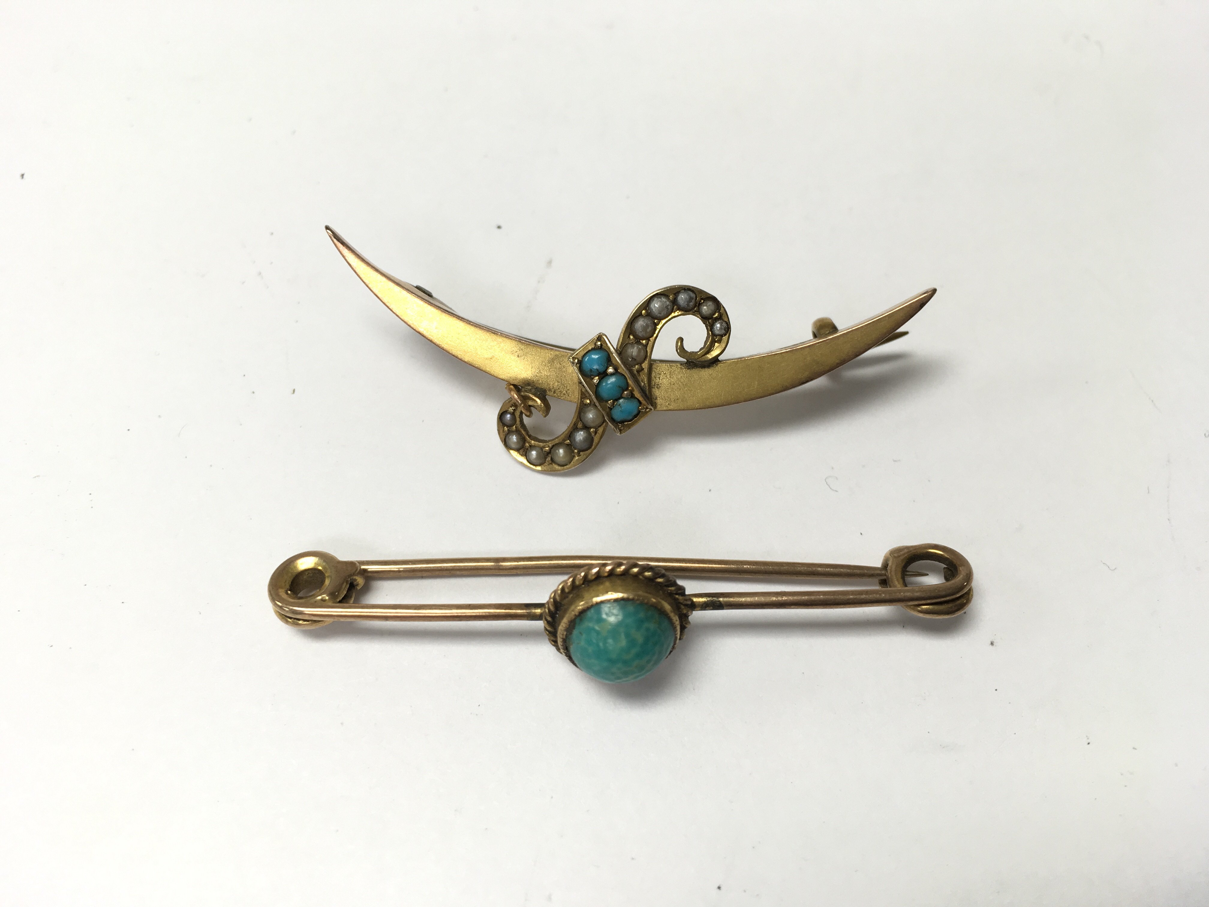 A pair of 9ct gold brooches with turquoise stones