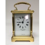 A brass bound carriage clock by Mappin & Webb with Roman numerals with Tuscan style columns.