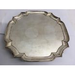 A silver Chippendale style tray raised on four bal