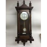 A modern wooden cased wall clock with metal dial