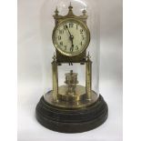 A brass mantal clock under glass dome