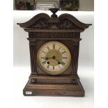 An Edwardian clock with Roman numerals together with two wooden framed mirrors.