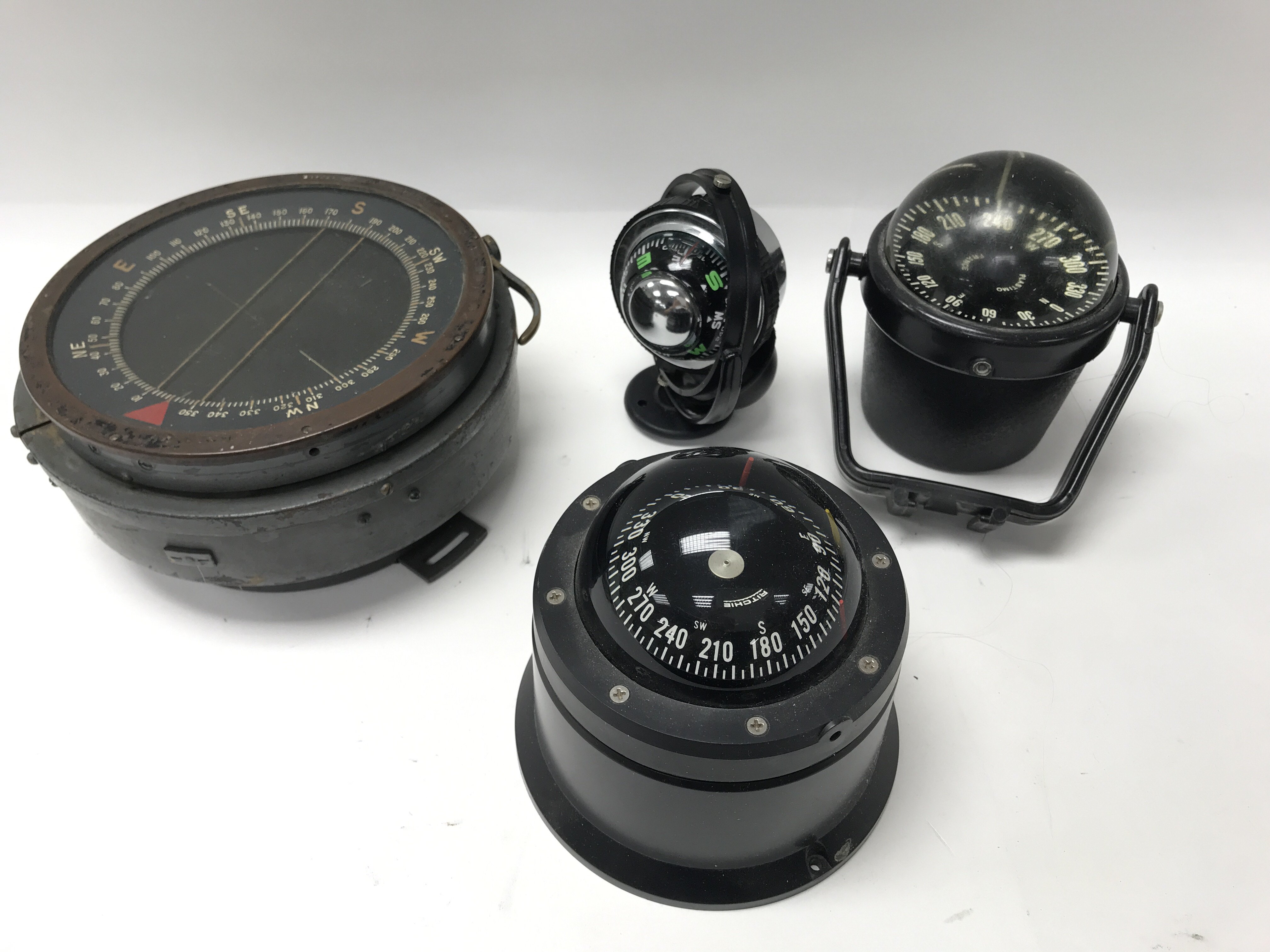 A collection of 6 compasses, a brass barometer, a boxed bracket mounted flasher echo sounder and a