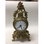 A brass cased French style clock with key.