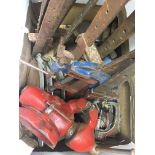 A box contains a collection of household tools, furntiure clamps, wood working tools, vices and