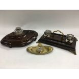 Three inkwells comprising two on wooden bases and