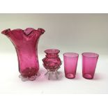 A collection of cranberry glass including vases.