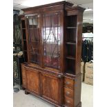 A George III Style Mahogany breakfront bookcase cabinet with a pair of glazed doors. flanked by open