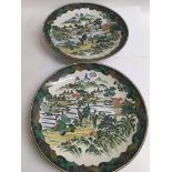 A pair of Japanese chargers decorated with figures flowers and foliage