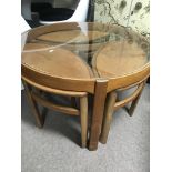 A 1970s nest of tables the glass top above three s