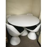 A 1970s white circular dining table with four matc