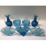 A collection of blue glass baskets and vases.