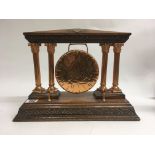 A copper gong fitted on a oak stand