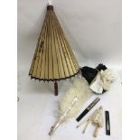 An ostrich feather and mother of pearl fan, glove stretchers, gloves and a parasol