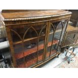 A walnut display cabinet with two glazed doors on cabriole legs and pad feet