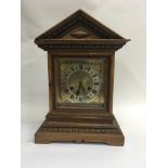 A oak mantle clock the silver dial with Roman nume
