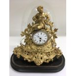 An ormolu spelter mantle clock under glass dome.Ap