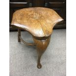 An elm saddle shape stool