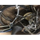 A box containing a collection of bicycle spares including wheels, handlebars, lights, crank wheels