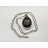 A silver pendant set with a large smoked quartz wi