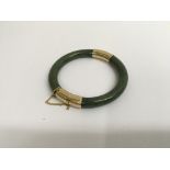 A jade bangle with unmarked gold clasp