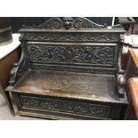 A carved oak late 19th Century hall seat with a ca