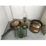 Copper pots and kettles, a trivet and an oil lamp