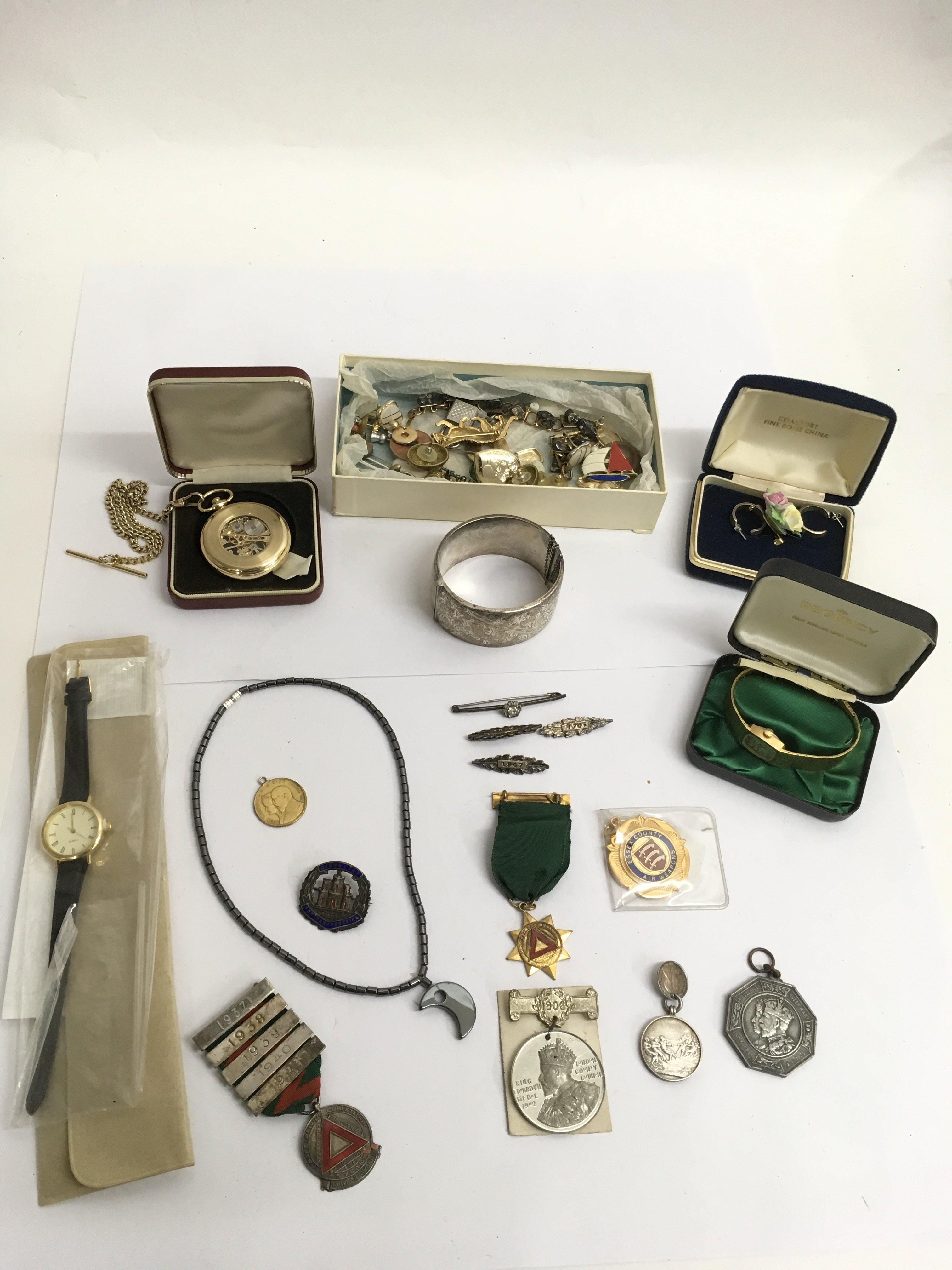 A silver bangle, watches, cufflinks and medallions