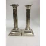 A pair of silver candle sticks on stepped bases Sh