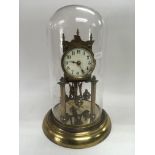 A brass clock under a glass dome, total height app