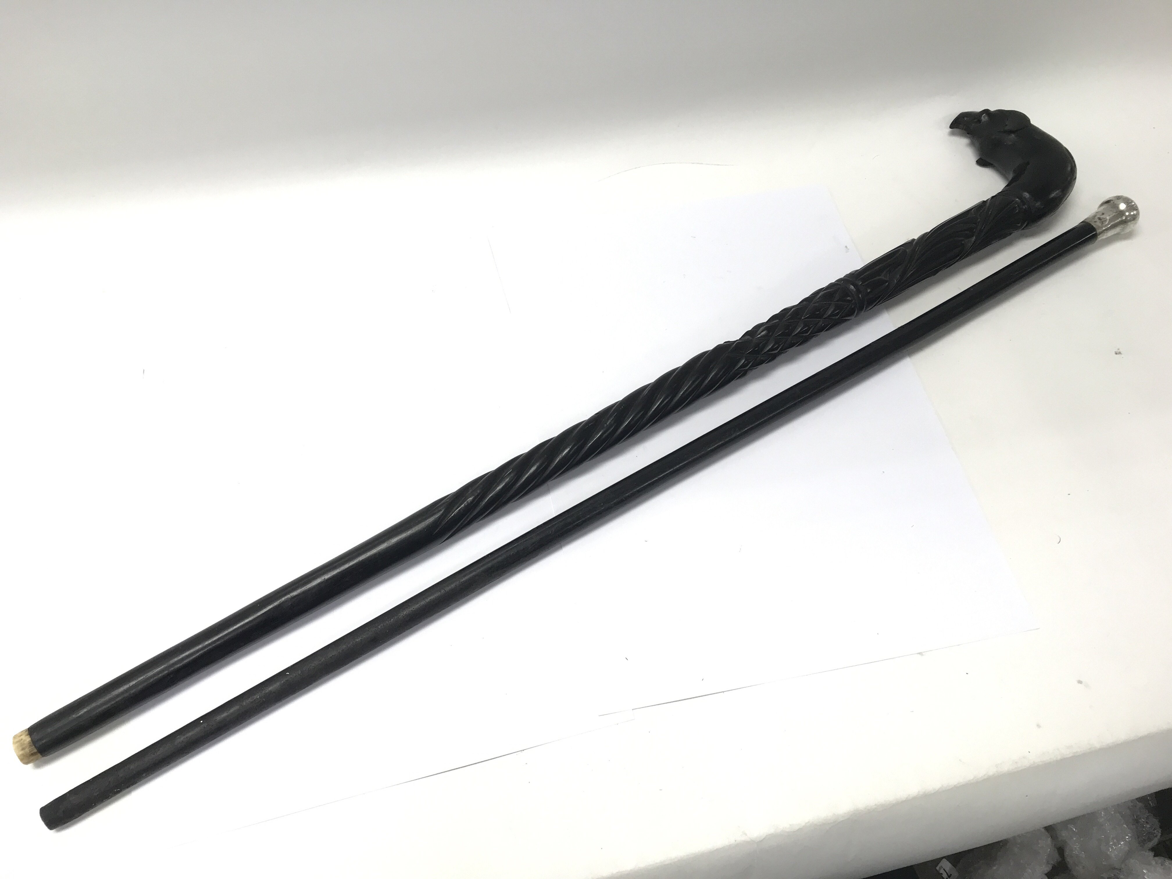 An ebony topped walking stick together with a silv