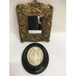 A framed religious relief study and a cherub framed mirror