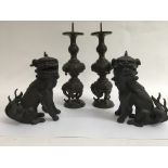 A pair of bronzed temple dogs and a pair of candle