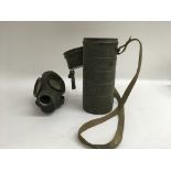 A German WW2 gas mask in original khaki green canister.