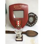 A collection of military sporting awards including a large wooden shield, unit plaque, wooden spoon,