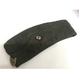 A RAD WW2 German side cap with metal RAD cap badge and enamel stick pin.