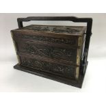 An Oriental carved wooden storage box with carryin