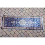 A Persian style silk runner on a blue ground with