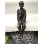 A 20th century bronze figure of a seated boy. Heig