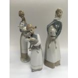 Three Lladro figures of girls holding lambs.