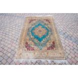 A Persian style silk gold and blue ground carpet,