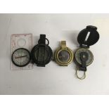 A collection of four pocket compasses