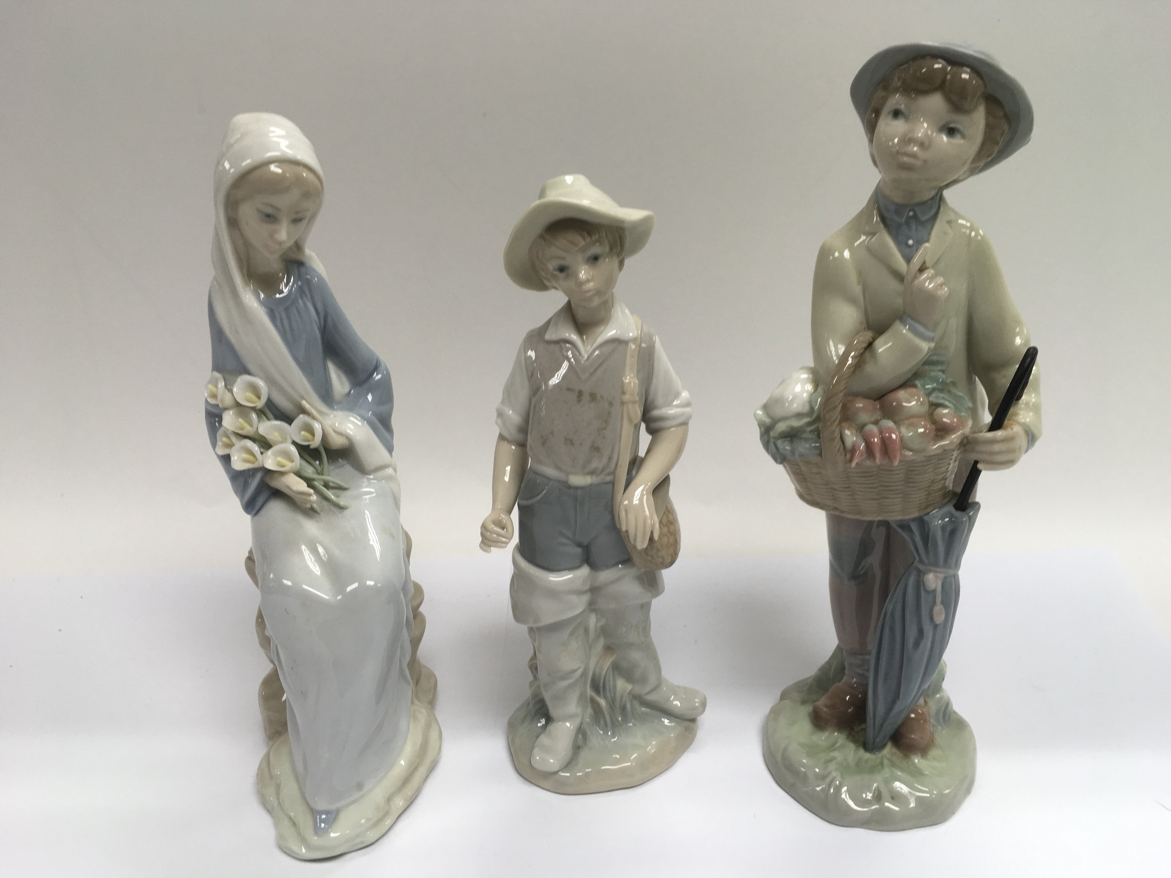 Three Lladro figures of children.