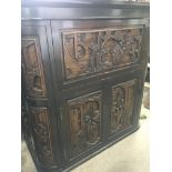 A cocktail cabinet the front profusely carved with