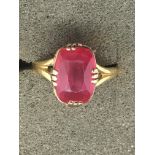 A gold ring set with a square cut ruby.Approx size